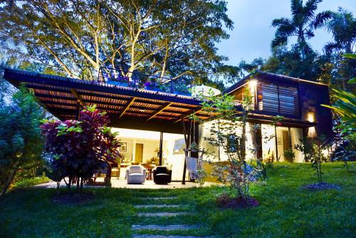 ein Haus mit einer Pergola inmitten eines Gartens in der Unterkunft LALDEA Nirvana Eco Villa in Cerritos in Pereira