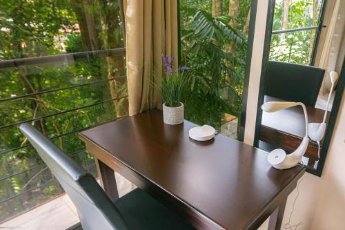 a wooden table with a chair and a window at Mountain Top Park Hotel in Quepos