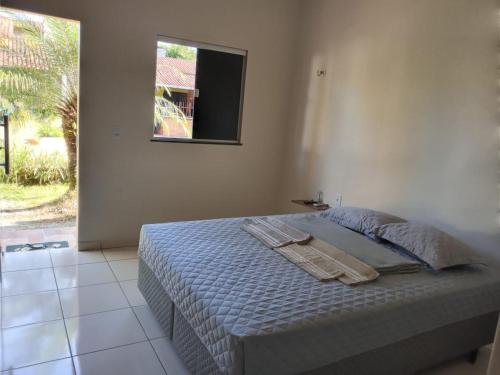 a bed in a bedroom with a window and a bedvisor at Pousada das Acacias in Carananduba