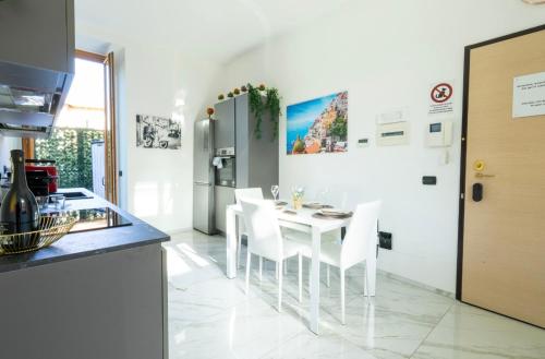 eine Küche mit einem weißen Tisch und weißen Stühlen in der Unterkunft Villa&Colombo in Rho