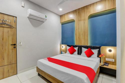 a bedroom with a large bed with red pillows at OYO Hotel Grand View in Surat