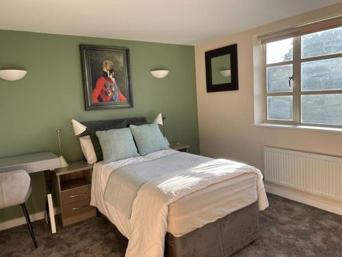 - une chambre avec un lit, un bureau et une fenêtre dans l'établissement Suitely Museum Residence with roof terrace, à Ipswich