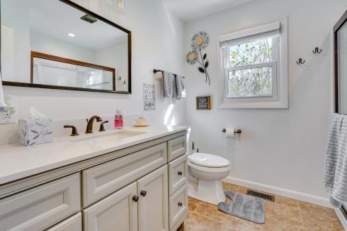 a bathroom with a sink and a toilet and a mirror at Hocking Hills Hideaway with Hot Tub and Fire Pit! in Logan