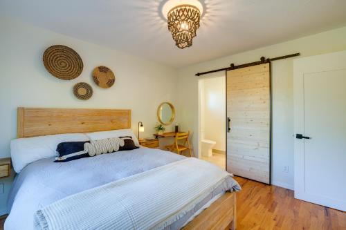 Un dormitorio con una cama grande y una lámpara de araña. en Seaside Home with Hot Tub and Patio Close to Beaches!, en Seaside