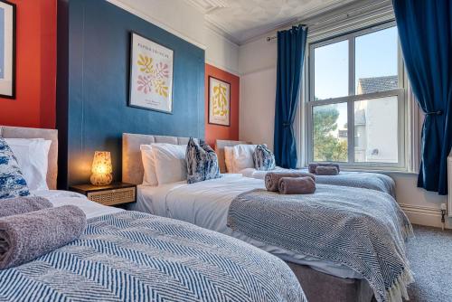 樸次茅斯的住宿－4 Bed Manor Design House, Modern, Spacious- Pet Friendly! Sleeps 9, Portsmouth - By Blue Puffin Stays，一间卧室设有两张床和窗户。