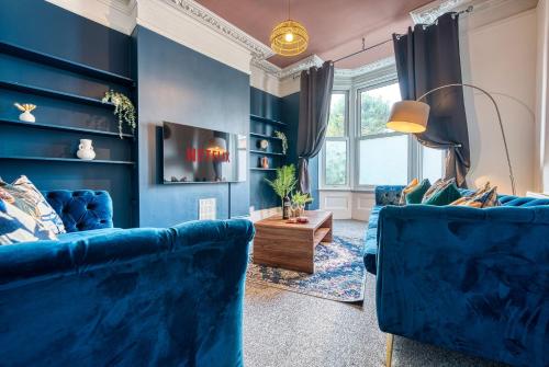 una sala de estar azul con 2 sofás azules en 4 Bed Manor Design House, Modern, Spacious- Pet Friendly! Sleeps 9, Portsmouth - By Blue Puffin Stays en Portsmouth