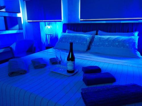 a blue room with a bed with a bottle of wine at Luxury b&b Le Rocce in Villasmundo