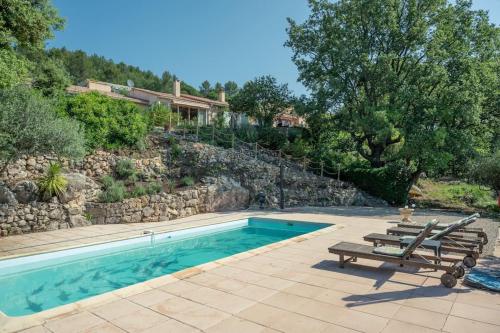 une piscine avec deux bancs et une maison dans l'établissement Location Maison provençale, Vacances Provence, Var, à Besse-sur-Issole