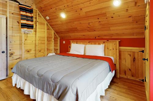 a bedroom with a bed in a wooden cabin at A Finger Lakes Favorite in Prattsburg