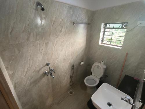 a bathroom with a sink and a toilet and a window at SHANKAR by the SEA, 2 min from Mandrem Beach in Mandrem