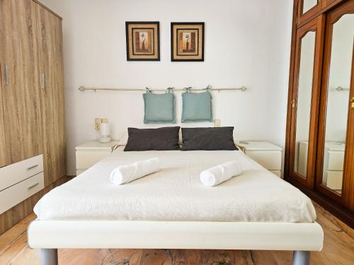 a bedroom with a large white bed with two pillows at Laguna Beach Costasol - Alojamientos La Torre in Torrox Costa