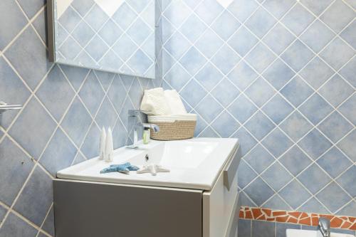 Nuovi Appartamenti Tri e Bilocali in Residence con Piscina a Porto Cervo 800mt Mare في ليسيا دي فاكا: حمام مع حوض ومرآة