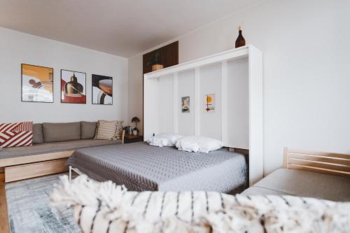 ein Schlafzimmer mit einem Bett und einem Sofa in der Unterkunft Scandic Primo Apartments - Design District 69m2 in Helsinki