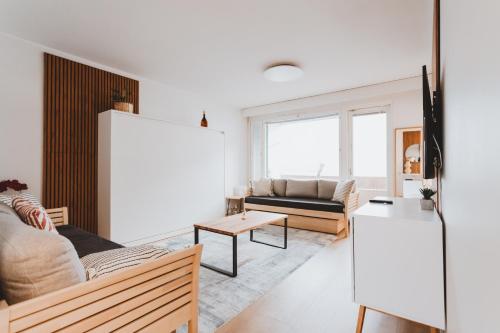 Scandic Primo Apartments - Design District 69m2 في هلسنكي: غرفة معيشة مع أريكة وطاولة