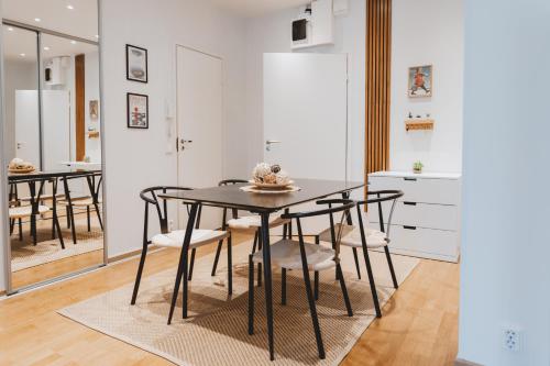 a dining room with a black table and chairs at Scandic Primo Apartments - Eerikinkatu 46m2 in Helsinki