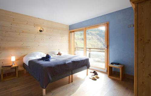 ein Schlafzimmer mit einem Bett und einem großen Fenster in der Unterkunft Chalet Norma by Leavetown Vacations in Les Deux Alpes