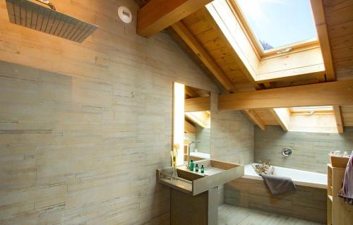 ein Bad mit einer Badewanne, einem Waschbecken und einem Fenster in der Unterkunft Chalet Norma by Leavetown Vacations in Les Deux Alpes