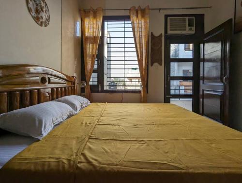 um quarto com uma cama grande com um cobertor amarelo em Zel’s Stay by Six Lane em Sohāna