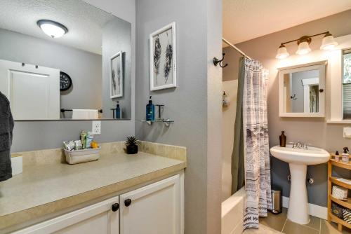 a bathroom with a sink and a toilet and a mirror at Charming Portland Home, Walk to Light Rail! in Milwaukie