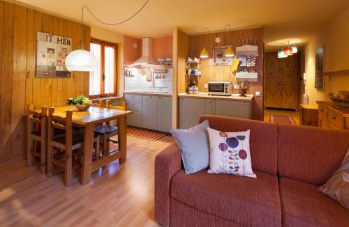 een woonkamer en een keuken met een bank en een tafel bij La Fleur, Morgex in Morgex