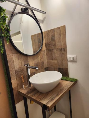 a bathroom with a white sink and a mirror at Le Volte B&B in Sammichele di Bari