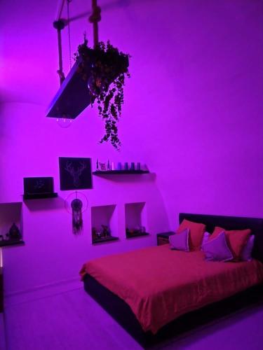 Un dormitorio con una habitación rosa con una cama en Le Volte B&B, en Sammichele di Bari