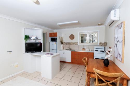 a kitchen with a wooden table and a dining room at Toowoomba Hospital Apartments in Rockville
