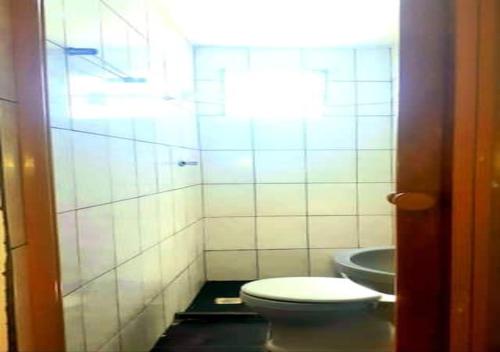 a bathroom with a toilet and a sink at Casa para temporada in Salvador