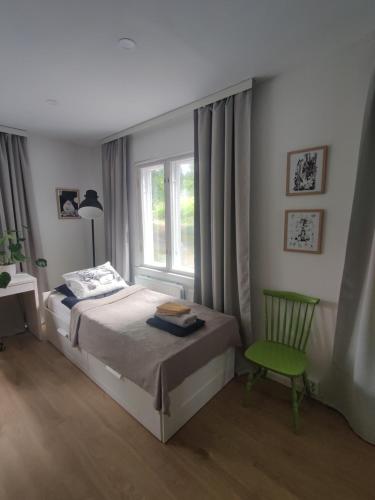 - une chambre avec un lit, une chaise et une fenêtre dans l'établissement Unique villa by the lake, à Lahti