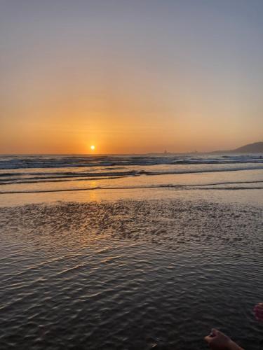 a sunset on a beach with the ocean at Résidence Borj-Dlalate City center Agadir in Agadir