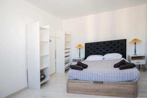 a bedroom with a bed with white walls and white shelves at "Évasion"-Meublé de Tourisme 3 étoiles -Résidence "Les Logis de Béziers"-Garage optionnel-Cœur de ville-Plages à 16km ! in Béziers