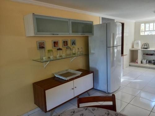 a kitchen with a white refrigerator and a table at Refugio na Serra 2 in Bananeiras