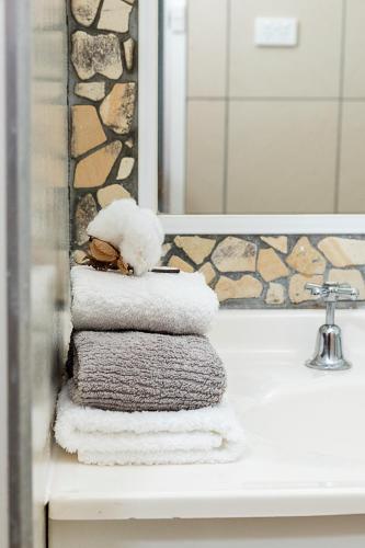 a pile of towels sitting on a sink in a bathroom at Toowoomba Hospital Apartments in Rockville