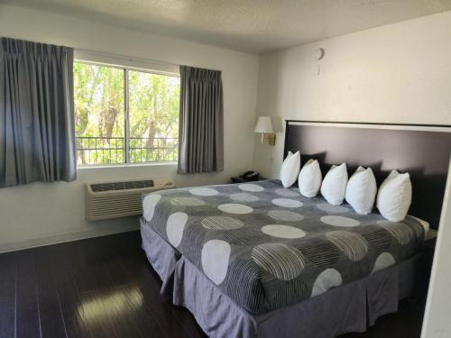 a hotel room with a bed with pillows and a window at The View Motel in Cottonwood