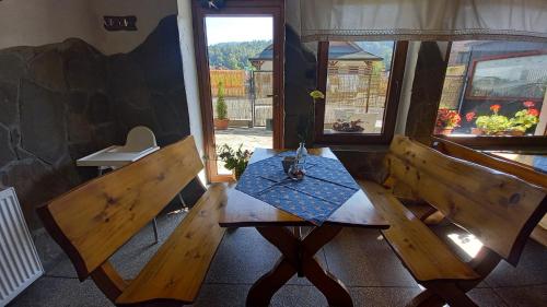 a table and two benches in a room at Pod Wodospadem in Szczyrk