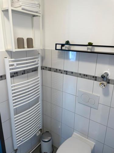 y baño con aseo blanco y lavamanos. en Ferienwohnung Hansezauber Lübeck, en Lübeck