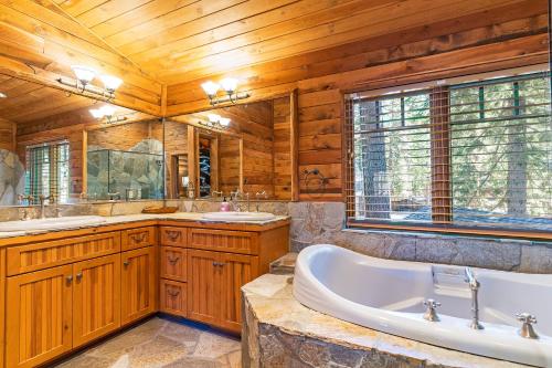 un baño con bañera y dos lavabos en 1138 Lakeshore - One-of-a-kind Lakeshore Boulevard log cabin, en Incline Village