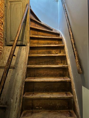 an old wooden staircase leading to a door at GiGi Home's in Antwerp