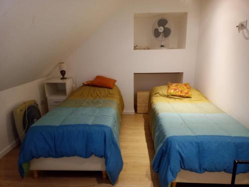 two twin beds in a room with a attic at Cálido Departamento Céntrico San Martín de los andes in San Martín de los Andes