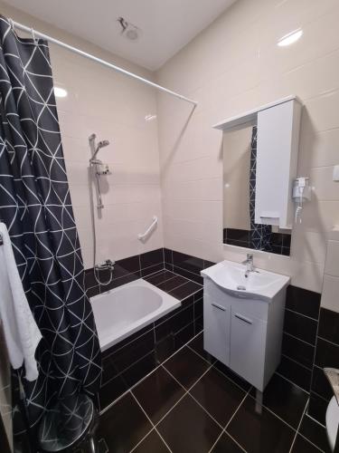 La salle de bains est pourvue d'une douche, d'un lavabo et d'une baignoire. dans l'établissement Holiday Resort Zlatni Dol Mostar, à Goranci