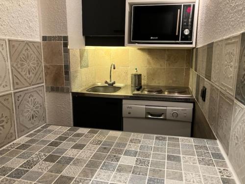 a small kitchen with a sink and a microwave at Le Mottet -Prariond - ESF & Skis aux pieds in Valmorel