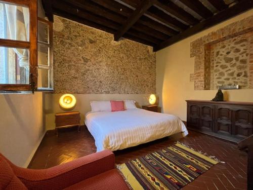 a bedroom with a bed and a chair in a room at Posada Colibri - Hotel & Spa in San Juan Teotihuacán