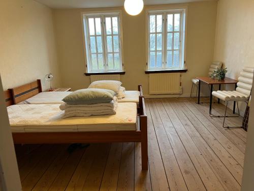 a bedroom with two beds and two windows at NordsoeHousing-Rørby in Kalundborg