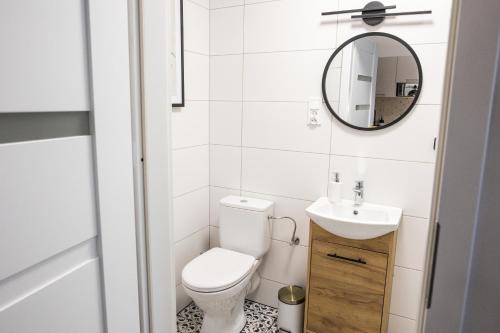 een badkamer met een toilet, een wastafel en een spiegel bij CracWoW K8 No.9 Apartment in Krakau