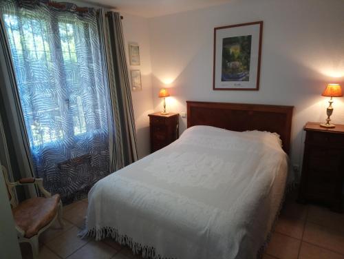 une chambre avec un lit blanc et une fenêtre dans l'établissement Villa Les Femades, à Laroque-des-Albères