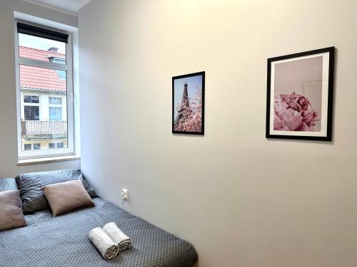 Pokój z kanapą i dwoma zdjęciami na ścianie w obiekcie MMRent Paris Room w Gdańsku