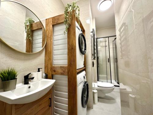 W łazience znajduje się umywalka, toaleta i lustro. w obiekcie MMRent Paris Room w Gdańsku