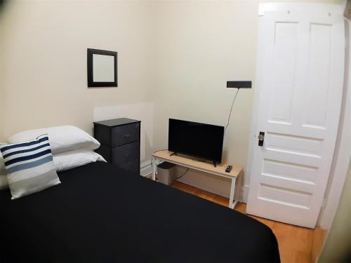 1 dormitorio con 1 cama y escritorio con ordenador portátil en The Roscoe Village Guesthouse, en Chicago
