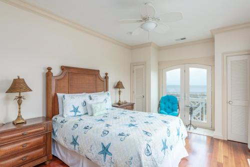 - une chambre avec un lit et une chaise bleue dans l'établissement Seascape on Harbor Island, à Oceanmarsh Subdivision