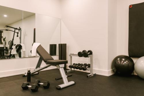 a room with a gym with a chair and weights at Reside NoMa, a Wyndham Residence in Washington